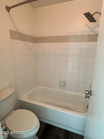 a white bath tub sitting next to a white toilet and a sink