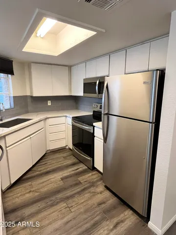 a kitchen with a refrigerator sink and cabinets