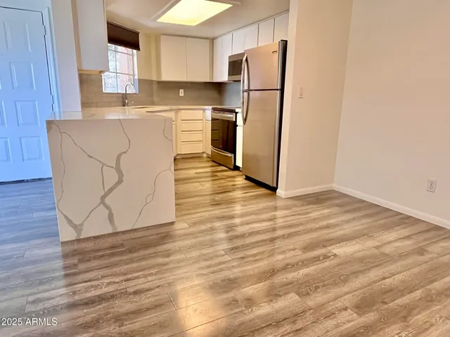 a kitchen with a refrigerator sink and cabinets