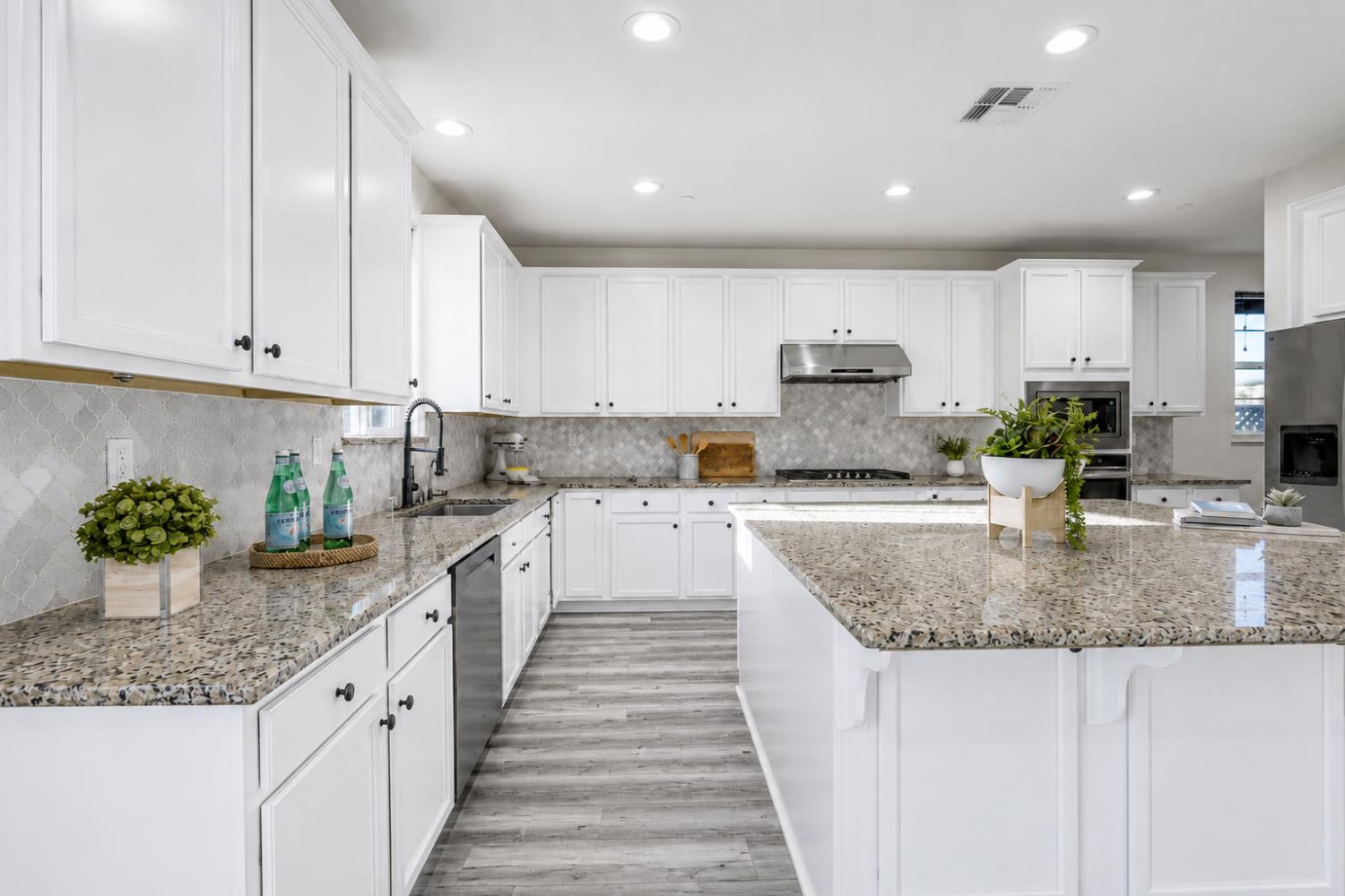 1837 South La Barbera Avenue Mountain House, CA 95391 - Photo 18 of 54 a kitchen with granite countertop a sink and white cabinets