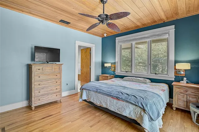 a bedroom with a bed a dresser and a flat screen tv