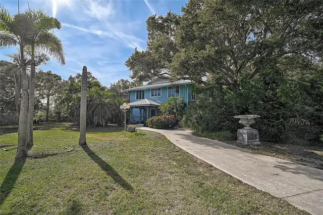 a view of a house with backyard and a tree