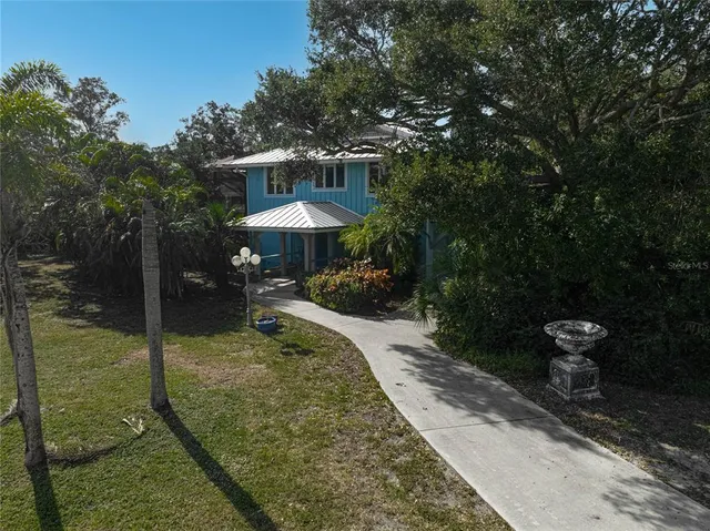 a backyard of a house with table and chairs under an umbrella