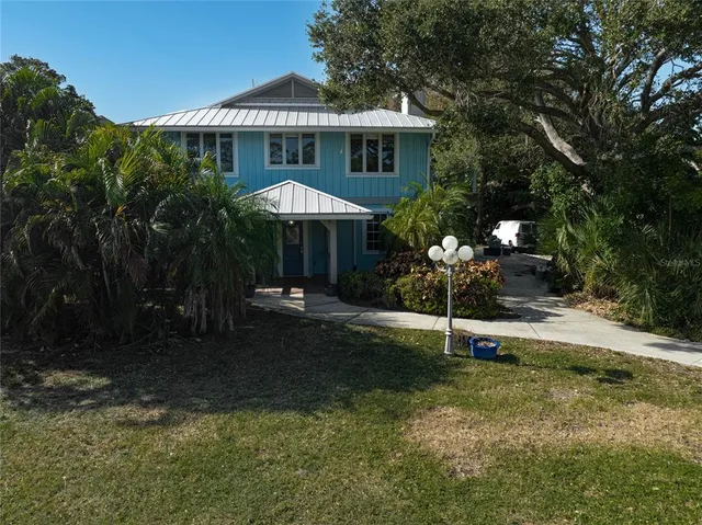 an aerial view of a house with a yard and lake view