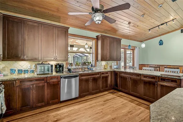 a kitchen with stainless steel appliances granite countertop wooden cabinets a sink and dishwasher