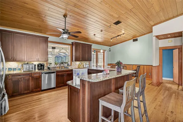 a kitchen with stainless steel appliances granite countertop a sink table and chairs