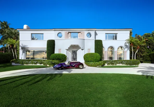 a front view of a house with a garden and plants