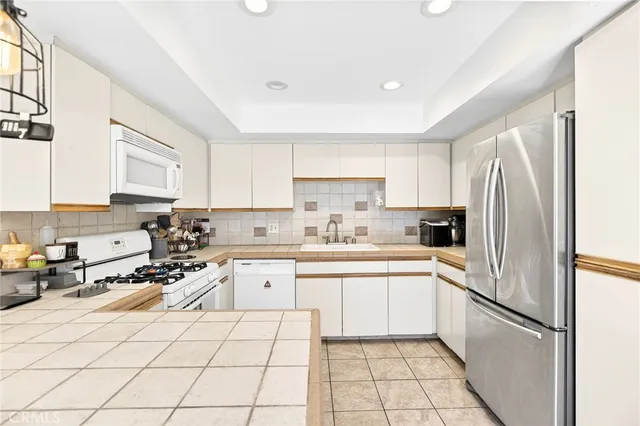 a kitchen with a refrigerator a sink and cabinets