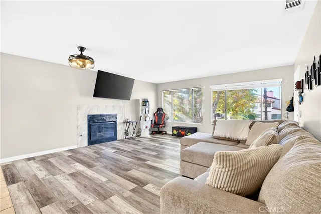 a living room with furniture a fireplace and a flat screen tv