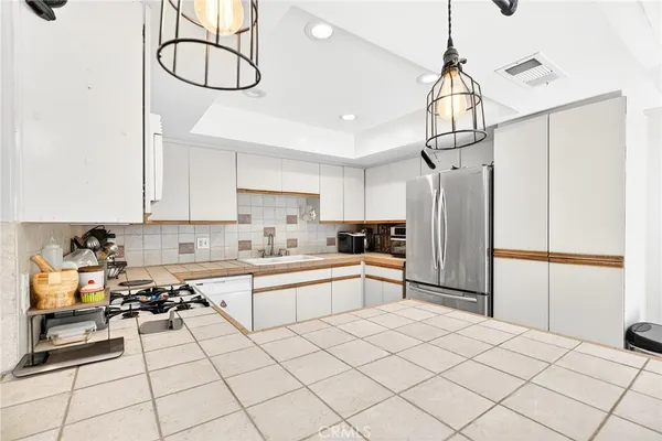 a kitchen with stainless steel appliances a refrigerator sink and cabinets