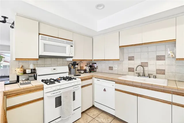 a kitchen with granite countertop a sink stove and cabinets
