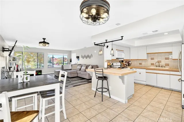 a kitchen with a sink dining table and chairs