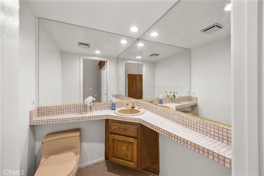 5895 Jadeite Avenue Rancho Cucamonga, CA 91737 - Photo 14 of 71 a bathroom with a granite countertop sink a toilet and mirror