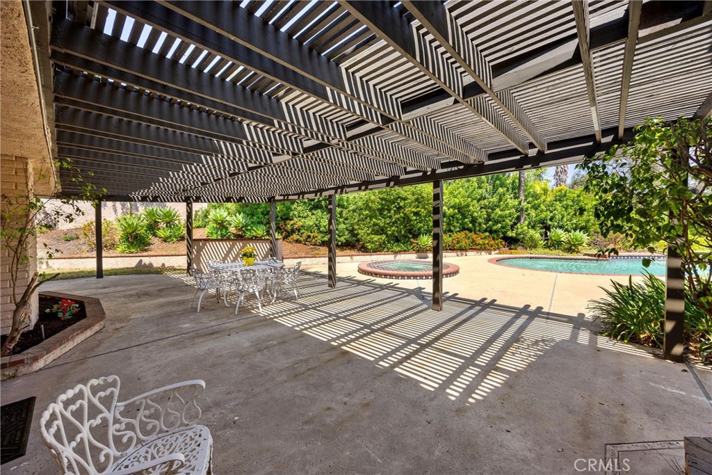 5895 Jadeite Avenue Rancho Cucamonga, CA 91737 - Photo 55 of 71 a view of a patio with table and chairs under an umbrella with a small yard