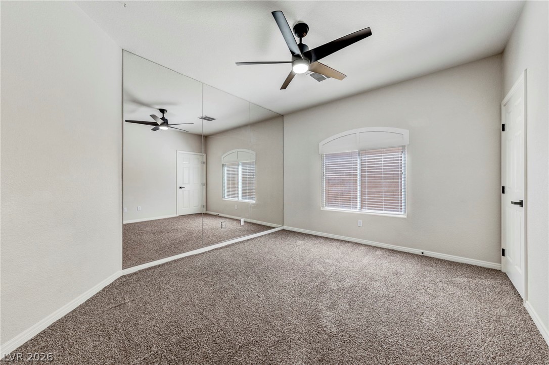 740 Aldo Rae Court, Unit NONE Henderson, NV 89052 - Photo 21 of 35 A well-lit bedroom with ample space and wall-to-wall carpeting awaits personalization.
