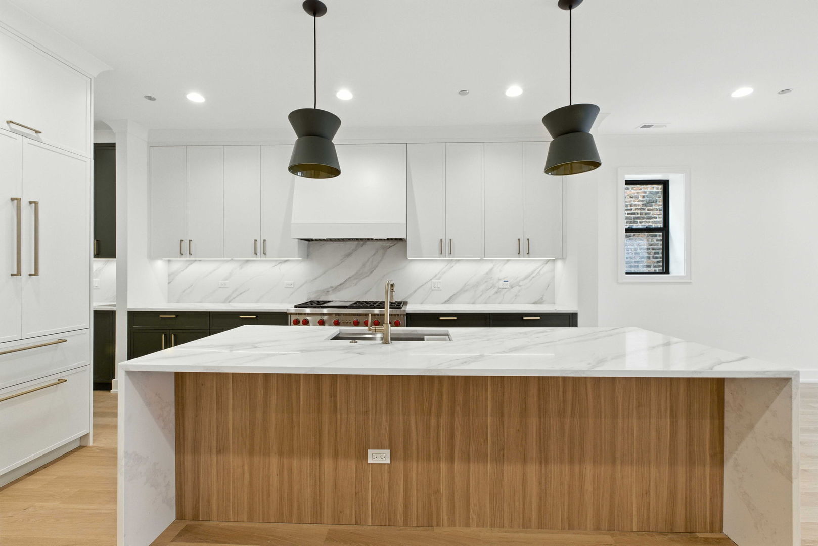 1443 West Roscoe Street, Unit 1 Chicago, IL 60657 - Photo 5 of 15 a kitchen with kitchen island a counter space a sink and a refrigerator