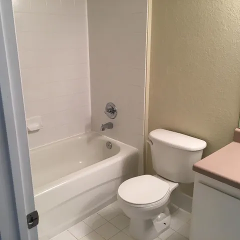 a white toilet sitting next to a bath tub