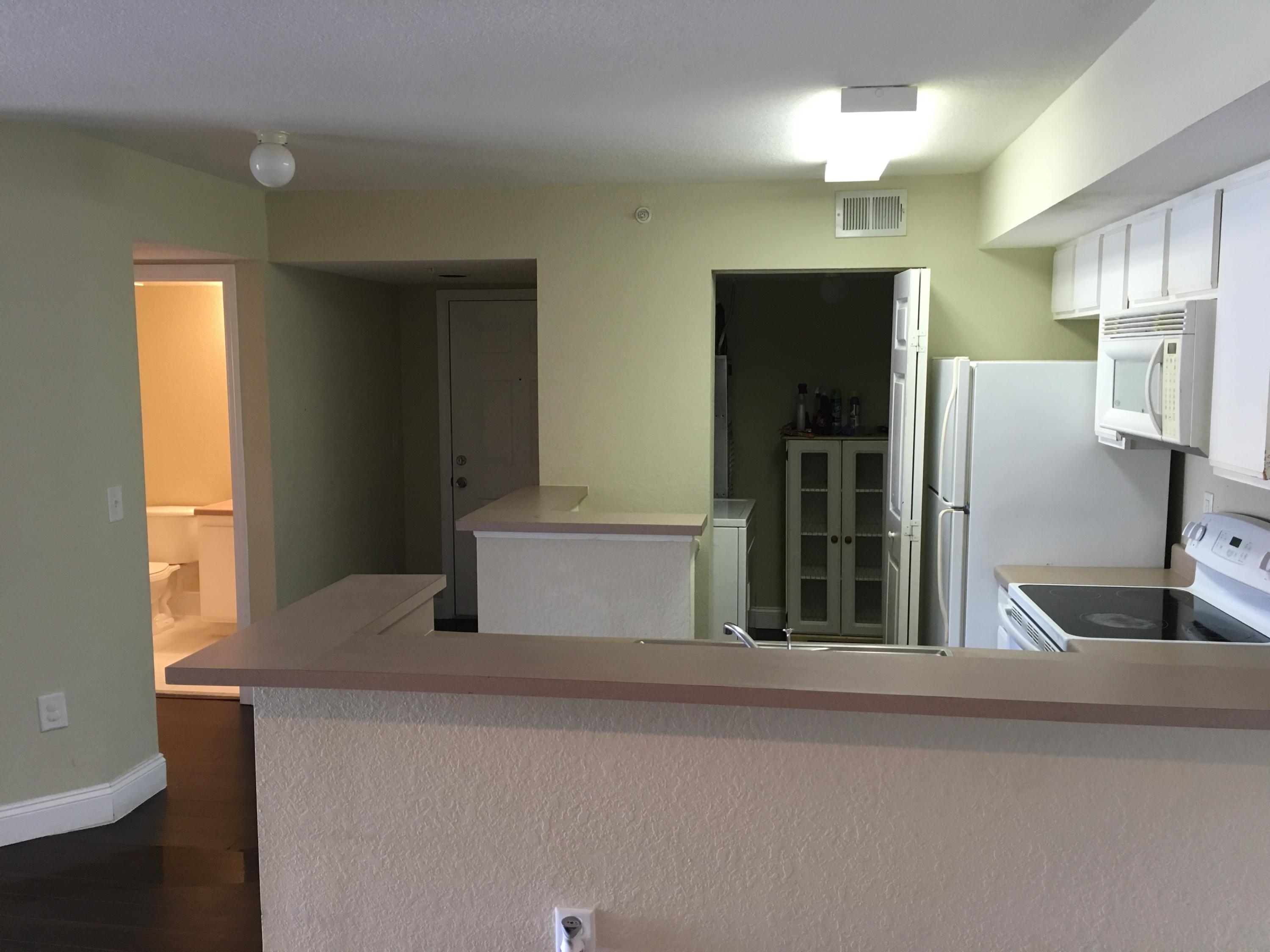 161 Southwest Palm Drive, Unit 205 Port St. Lucie, FL 34986 - Photo 8 of 22 a kitchen with stainless steel appliances kitchen island a refrigerator sink and cabinets
