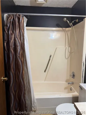 a bathroom with a shower curtain and a toilet