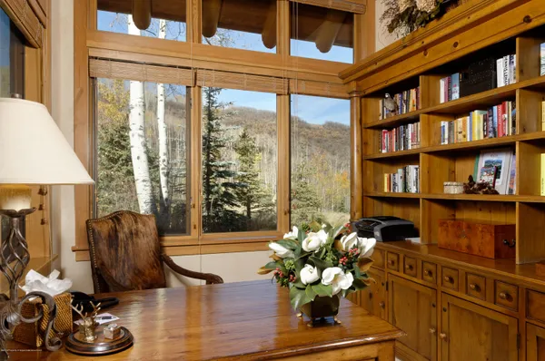 a living room with furniture bookshelf and a large window