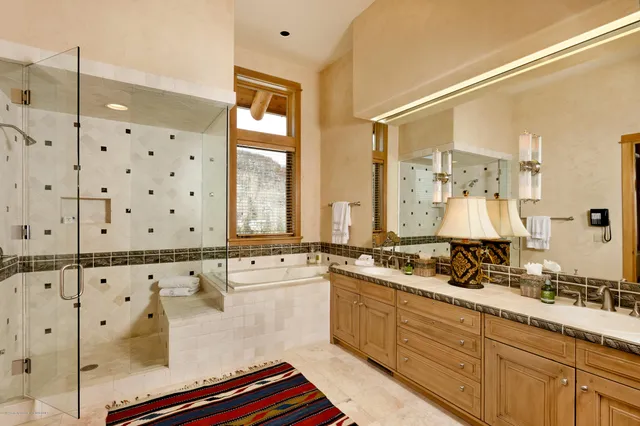 a bathroom with double vanity and a bathtub