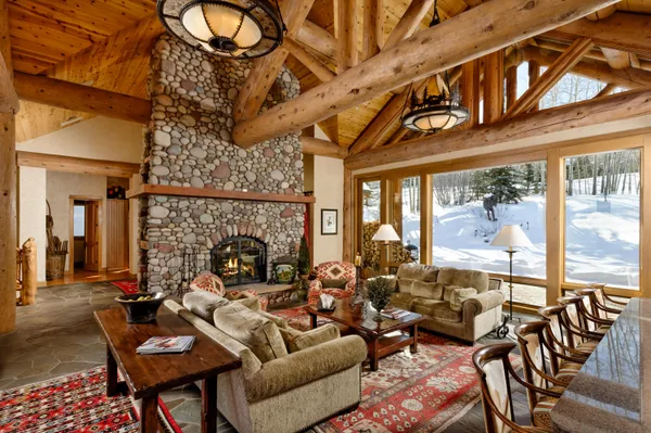 a living room with furniture a floor to ceiling windows and a rug