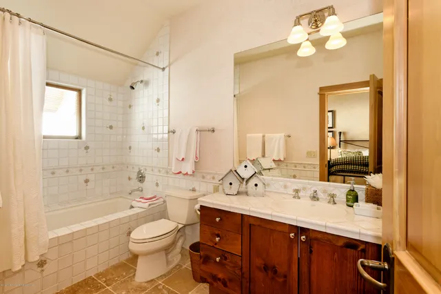a bathroom with a double vanity sink a toilet and shower