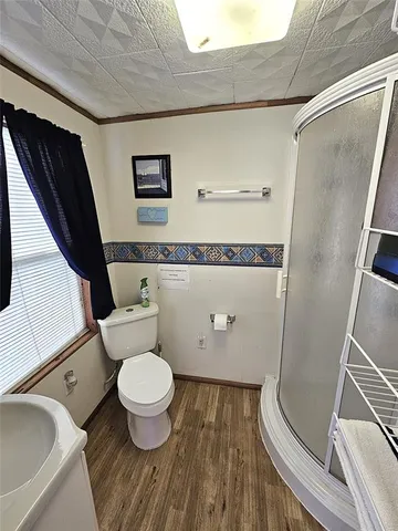 a view of grassy field with benches and trees all around