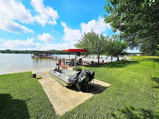 a view of a swimming pool and lounge chairs in back yard of the house
