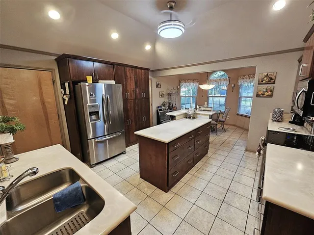 a kitchen with stainless steel appliances a sink a stove a refrigerator and cabinets