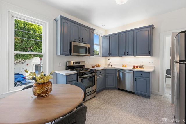 a kitchen with granite countertop a stove sink and cabinets