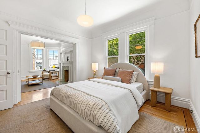 a bedroom with a bed couch and a large window