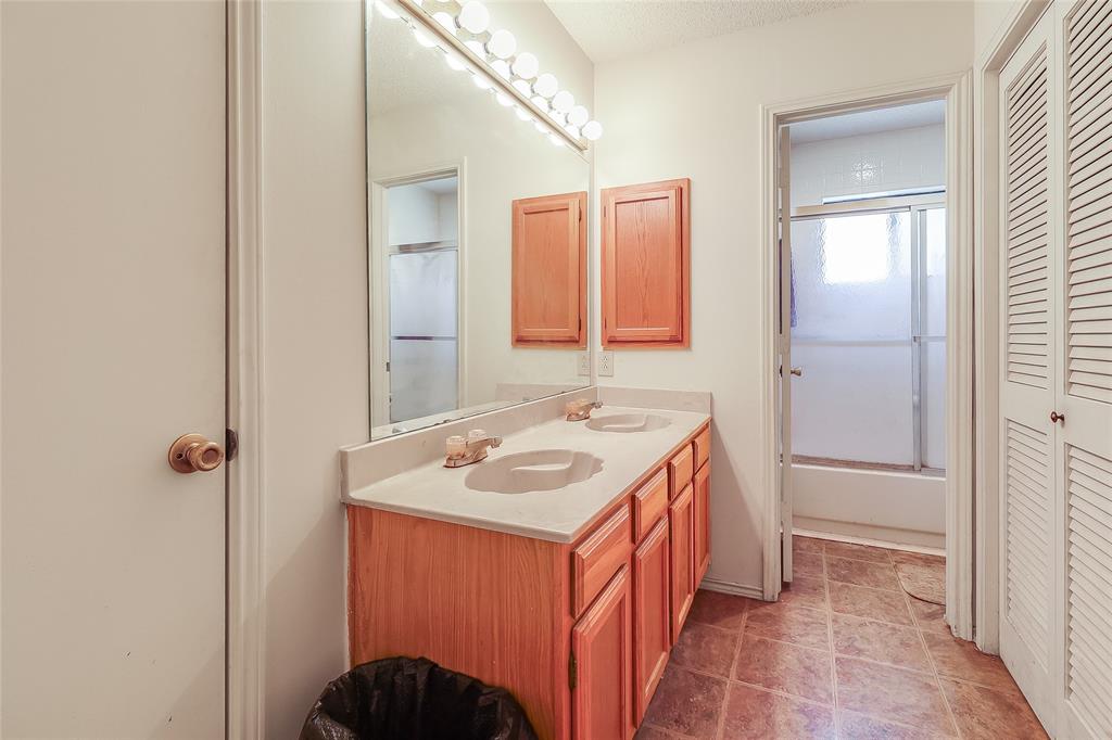 1728 Hackamore Street Mesquite, TX 75149 - Photo 14 of 22 Bathroom featuring a closet, double vanity, and shower / bath combination with glass door