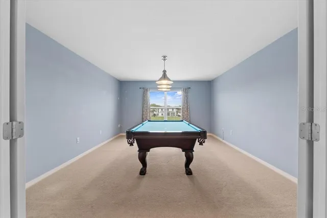 a room with pool table and windows