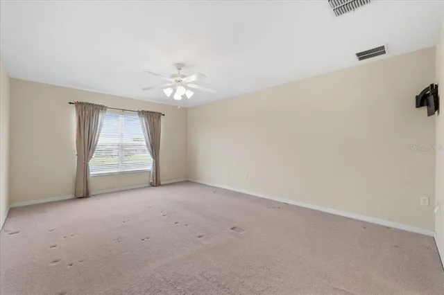 an empty room with windows and fireplace