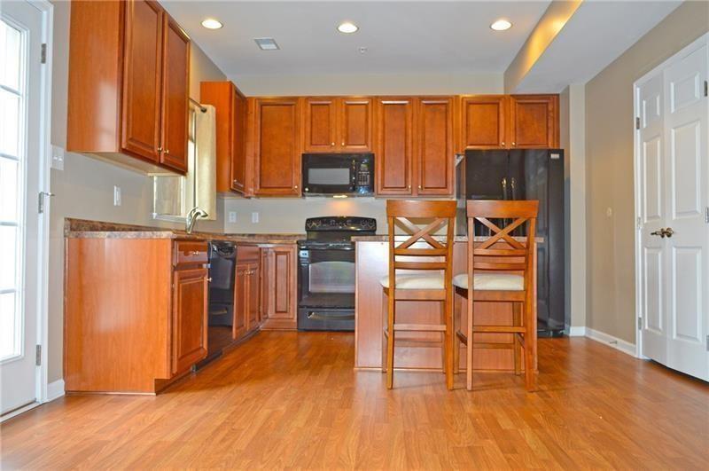 317 Maple Ridge Drive Canonsburg, PA 15317 - Photo 4 of 20 a kitchen with stainless steel appliances a microwave a stove a refrigerator a sink dishwasher and wooden cabinets with wooden floor
