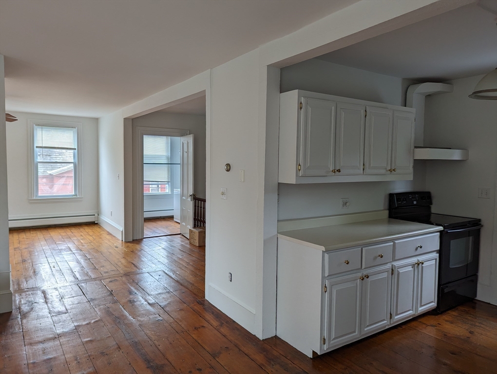 33 Merrill Street, Unit 3 Newburyport, MA 01950 - Photo 11 of 17 a kitchen with cabinets and wooden floor