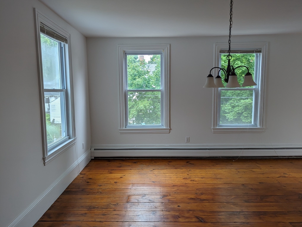 33 Merrill Street, Unit 3 Newburyport, MA 01950 - Photo 6 of 17 an empty room with wooden floor and windows