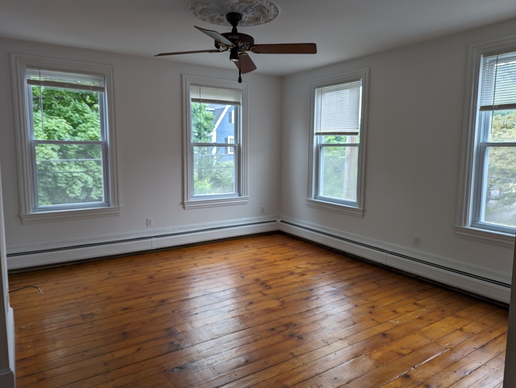 33 Merrill Street, Unit 3 Newburyport, MA 01950 - Photo 8 of 17 a view of an empty room with wooden floor and a window
