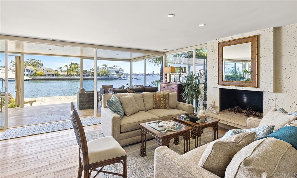 7 Beacon Bay Newport Beach, CA 92660 - Photo 10 of 59 a living room with furniture a fireplace and a floor to ceiling window