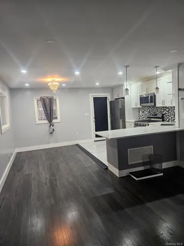 a view of a kitchen with kitchen island a sink stainless steel appliances and cabinets