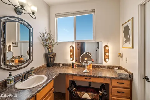 a bathroom with a granite countertop sink a mirror and vanity