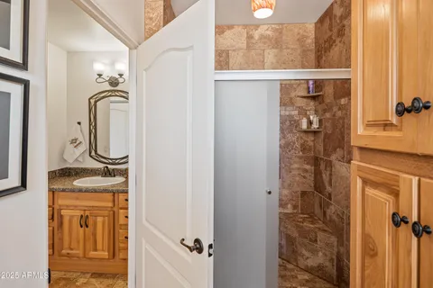 a bathroom with a granite countertop shower a mirror and a sink