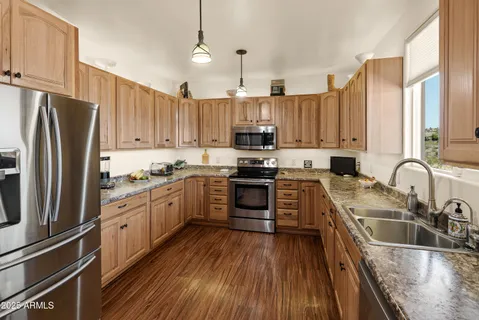 a kitchen with kitchen island granite countertop a sink appliances cabinets and counter space