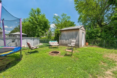 a view of a backyard with couches under an umbrella