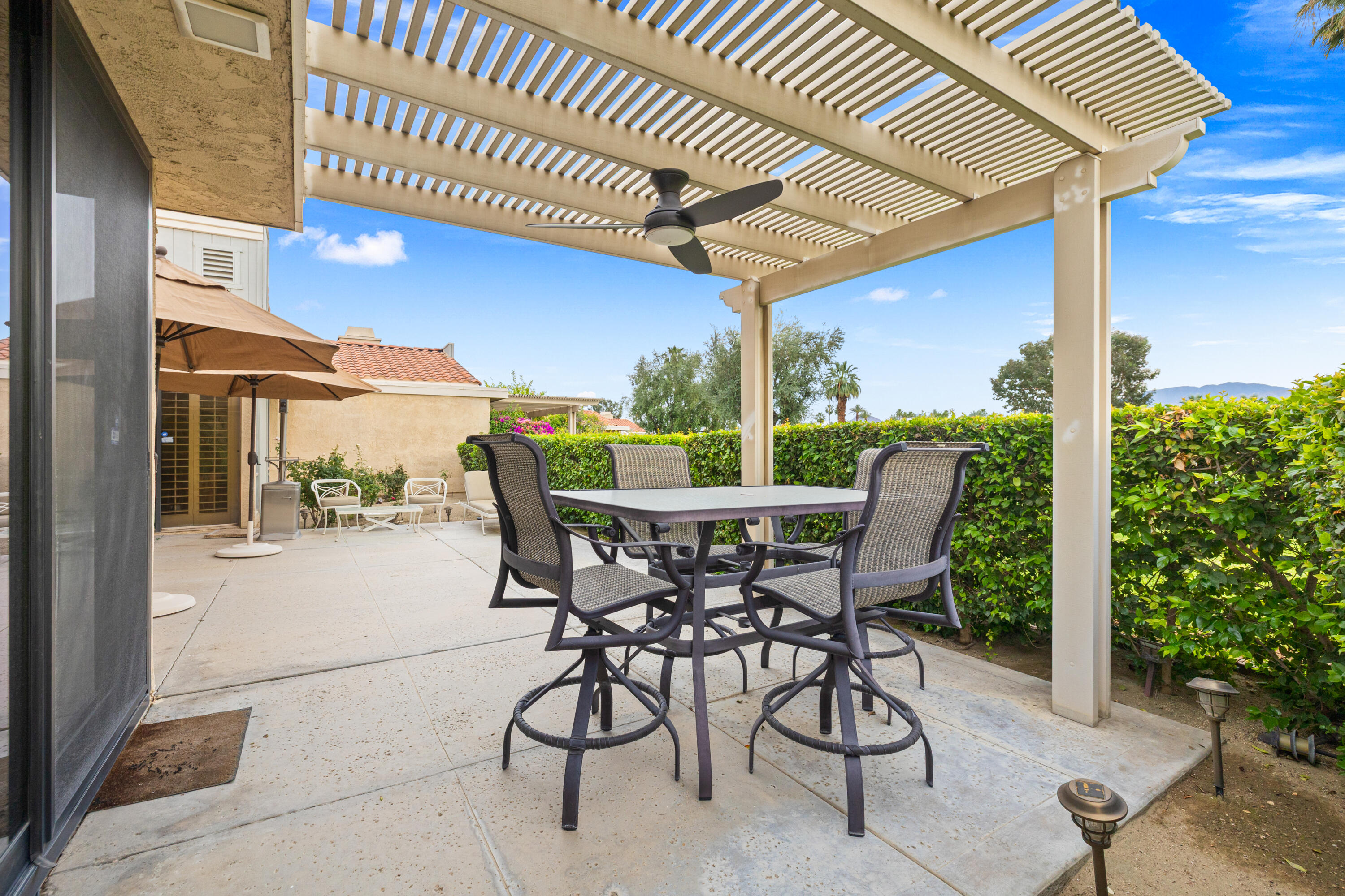 72419 Rodeo Way Rancho Mirage, CA 92270 - Photo 43 of 48 a view of a patio with a table chairs and a backyard