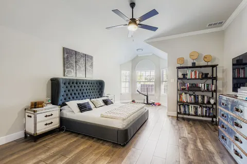 a bedroom with a bed a flat screen tv and a window