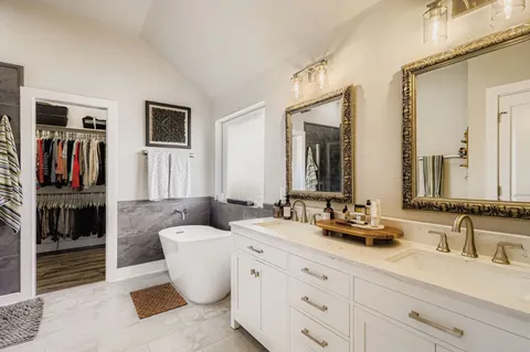 a bathroom with a double vanity sink a mirror and a window
