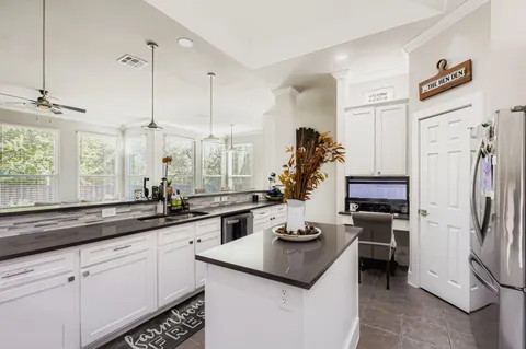 a kitchen with stainless steel appliances granite countertop a sink and a refrigerator