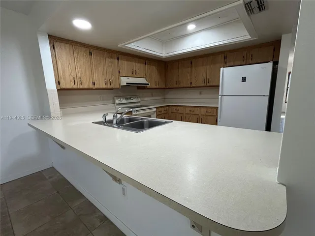 a kitchen with a refrigerator a sink and cabinets